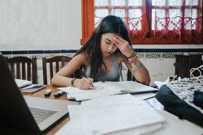 Una chica se agobia estudiando los exámenes finales.