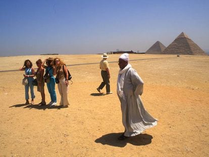 Un grupo de turistas frente a las pirámides de Giza, en El Cairo (Egipto).