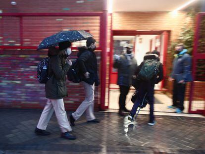 Varios alumnos entran al colegio Arcangel Rafael, en Aluche, el día de la reapertura de los centros educativos tras la gran nevada de 'Filomena'.