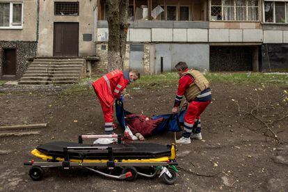 Trabajadores médicos recogen el cuerpo de una mujer, después de un bombardeo ruso en Járkov (Ucrania).