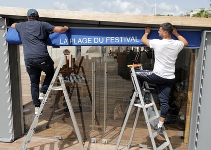 Trabajadores preparan las instalaciones de un club de playa en Cannes