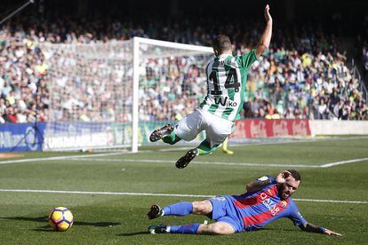 El jugador del Betis Durmisi salta por encima del jugador del Barcelona, Aleix Vidal.