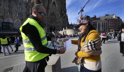 Un mosso repartint díptics a una turista a la Sagrada Família.
