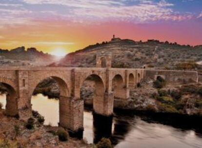 Vista del puente romano de Alcántara (Cáceres), sobre el Tajo, al atardecer.