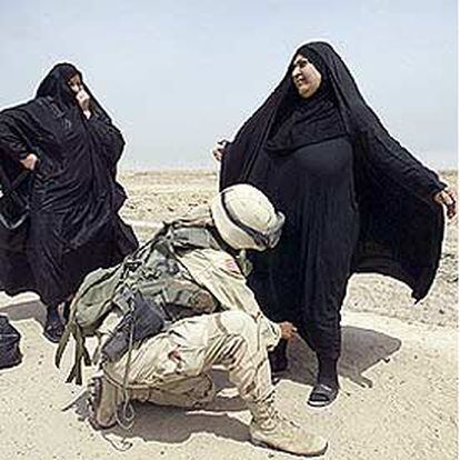 Una soldado estadounidense cachea a dos mujeres iraquíes en el puerto de Um Qasr, al sur de Irak.