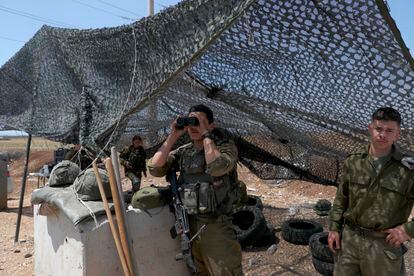 Un soldado israelí usa vigila con unos prismáticos desde su posición, ubicada en la valla de seguridad cerca de la ciudad cisjordana de Jenin, este 3 de julio de 2023.