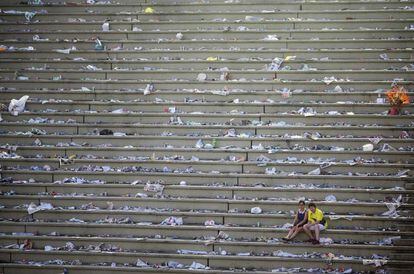 Unos turistas descansan en el sambódromo, lleno de basura, después del desfile anual de Carnaval en Río de Janeiro (Brasil).
