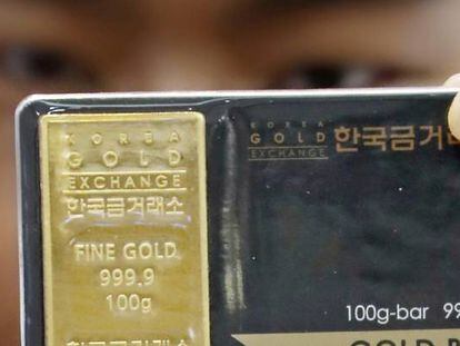 Un trabajador del Korea Gold Exchange muestra lingotes de oro en Se&uacute;l (Corea del Sur).