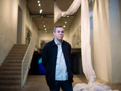 Fernando Sánchez Castillo posa ante su obra 'Coreografía 01', la gran bandera blanca que exhibe en su exposición en Madrid.
