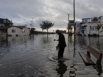 Un residente camina por una calle inundada, después de que las tormentas azotaran el norte de California, en la ciudad costera de Aptos, el 5 de enero de 2023.