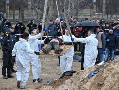 Forensic investigators exhumed a body from a mass grave in Bucha on Friday.