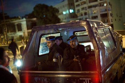 Un vehículo que traslada a policías egipcios es detenido en un puesto de control establecido por vecinos de un barrio de El Cairo, en uno de los extremos de un puente sobre El Nilo.