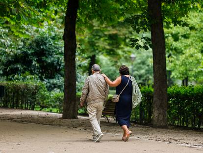 Dos personas mayores pasean por el parque del Retiro, en Madrid.