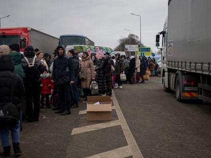 Varias personas y niños, esperan para cruzar a Rumanía, en el paso fronterizo de Porubne, a 5 de marzo de 2022, en el oeste de Ucrania.