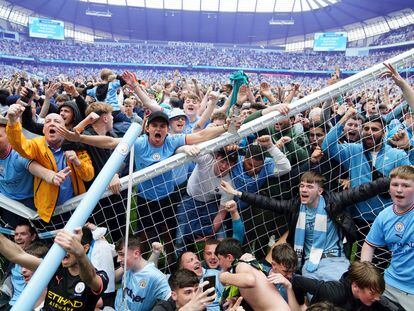 Aficionados del Manchester City rompen una de las porterías tras invadir el campo del Etihad, el domingo.