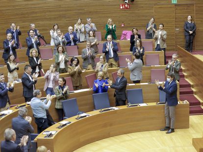 El presidente de la Generalitat, Carlos Mazón (d) aplaude a su grupo parlamentario tras la aprobación de los primeros presupuestos del Gobierno PP-Vox.