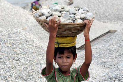 Payel, de siete años de edad, carga piedras en una cesta en la orilla del rio Balason, en las afueras de la ciudad india de Siliguri.