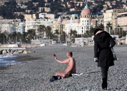 Un hombre en traje de baño se toma un selfi en la playa del Paseo de los Ingleses el 17 de enero de 2017 en Niza (Francia).