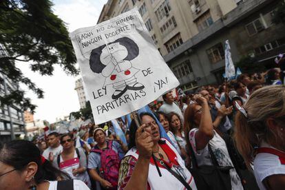 Una mujer exhibe una pancarta con un dibujo de Mafalda, el personaje de Quino.