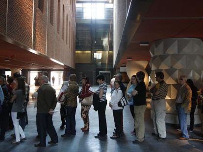 Un grupo de personas esperan para acceder al atrio del centro multicultural de la Alh&oacute;ndiga.