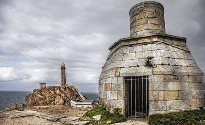 El faro de Vilán, al fondo, y la antigua linterna de aceite, en primer plano, en la Costa da Morte (A Coruña).