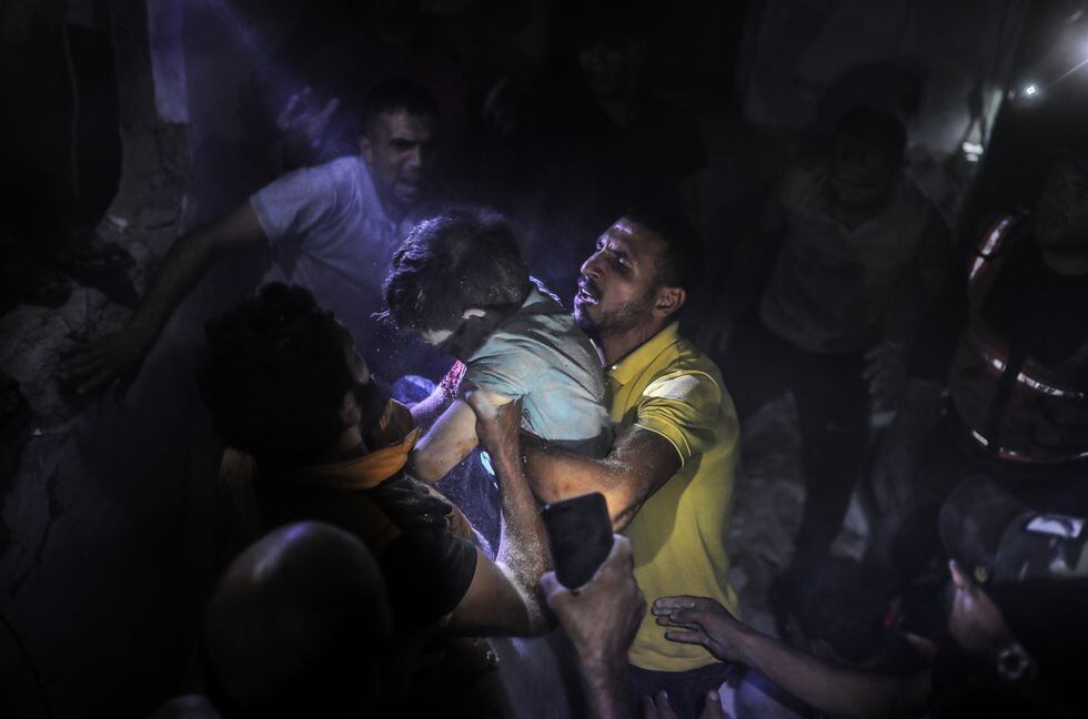 Palestinos rescatan a un niño niño palestino herido en un bombardeo de Israel en la localidad gazatí de Jan Yunis, este miércoles. ER 11: A wounded child is being rescued as civilians and members of civil defense teams conduct search and rescue operations to save people from under rubble of a collapsed building hit during an Israeli airstrike in Khan Yunis, Gaza on October 11, 2023. (Photo by Belal Khaled/Anadolu via Getty Images)