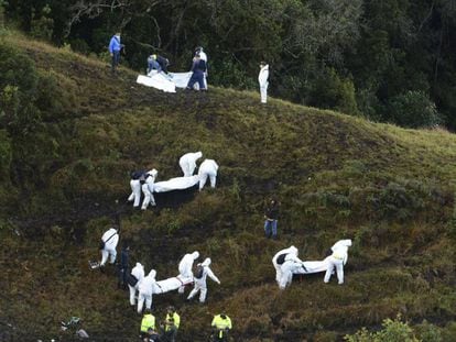 Un grupo de rescatistas traslada los cuerpos de los fallecidos en el accidente a&eacute;reo del Chapecoense.