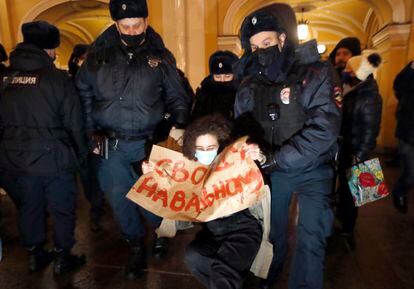Dos policías detienen a una mujer que lleva una pancarta con el lema "libertad para Navalni", este lunes en San Petersburgo. 