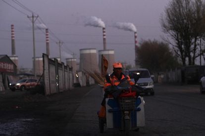 Varios vehículos pasan ante una central eléctrica alimentada por carbón en la ciudad china de Datong