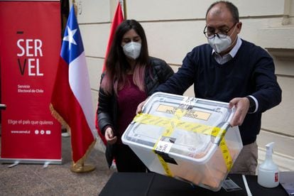 Trabajadores electorales sostienen una caja con votos, el pasado 13 de marzo en Santiago de Chile.