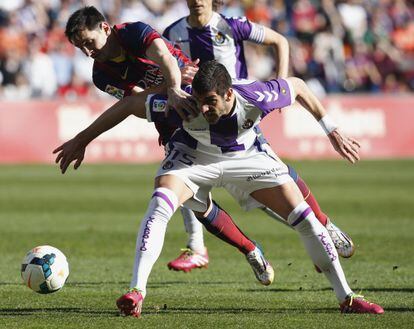 Mitrovic impide el avance de Messi.