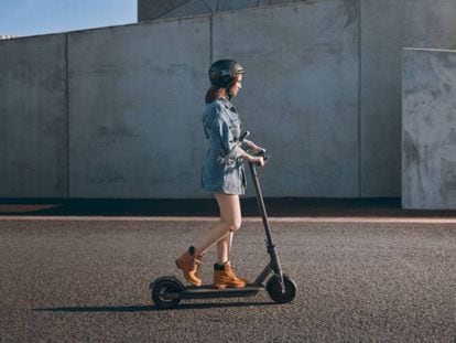 Una mujer pasea por la calle subida en el patinete eléctrico Xiaomi Mi Electric Scooter Pro.