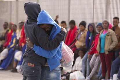 Abrazo entre dos inmigrantes del centro de internamiento para extranjeros en Lampedusa esperando a ser trasladados a la península.