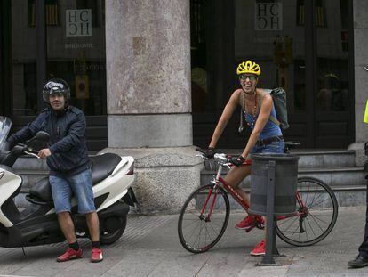 Un motorista, una ciclista y un policía en la Via Laietana