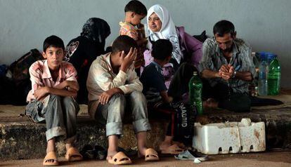 Una familia de refugiados sirios esperan a la entrada de Turquía.