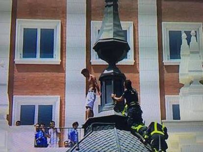 Bomberos acercándose al hombre que amenazaba con lanzarse a la Gran Vía.