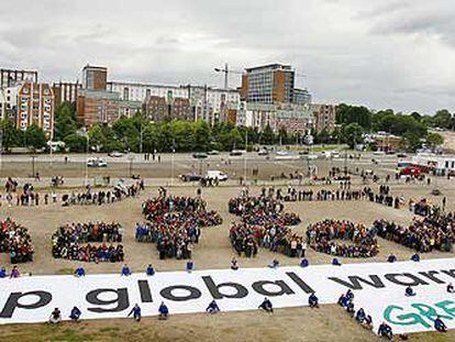 Protesta organizada ayer por Greenpeace en el puerto de Rostock, en la que un cartel gigante pide que se detenga el calentamiento global.