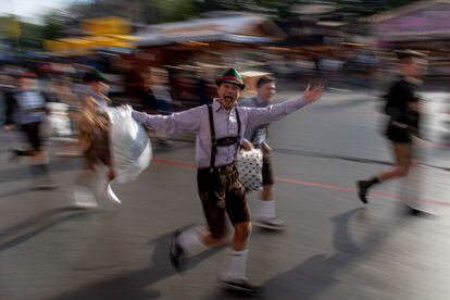 Visitantes entran corriendo al Oktoberfest la mañana de su inauguración.