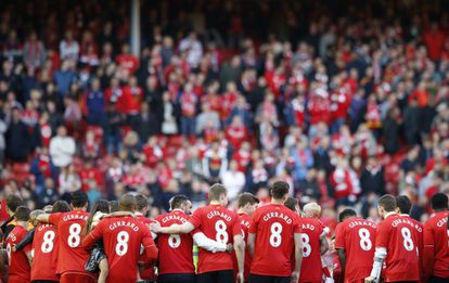 Los jugadores del Liverpool se abrazan con la camiseta de Gerrard.