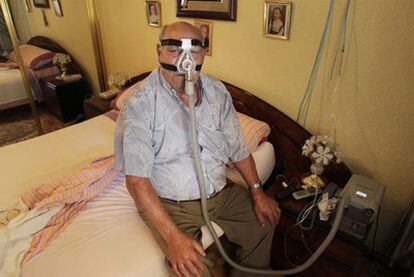 José Oti, en su casa, conectado al respirador eléctrico que le acompaña a diario.