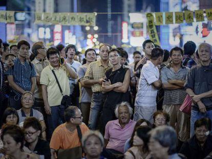 Un grupo de personas escucha un discurso improvisado por organizadores del movimiento prodemocracia en Hong Kong, este lunes.