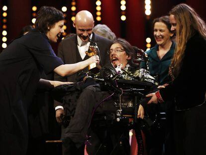 Adina Pintilie comparte su Oso de Oro con sus actores T&oacute;mas Lemarquis (detr&aacute;s) y Christian Bayerlein, en silla de ruedas.