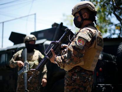 Soldados prestan guardia en un punto de control, en San Salvador.