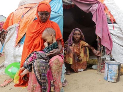 Una mujer somalí sostiene a su hija, mientras su abuela la observa, fuera de su refugio improvisado en el campamento de desplazados internos de Alla Futo, en las afueras de Mogadiscio, Somalia, el pasado septiembre.