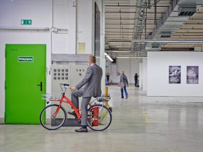 Bertram Schultze, desarrollador del proyecto MIB/ Auf AEG, subido a una bicicleta en el Hall 15.