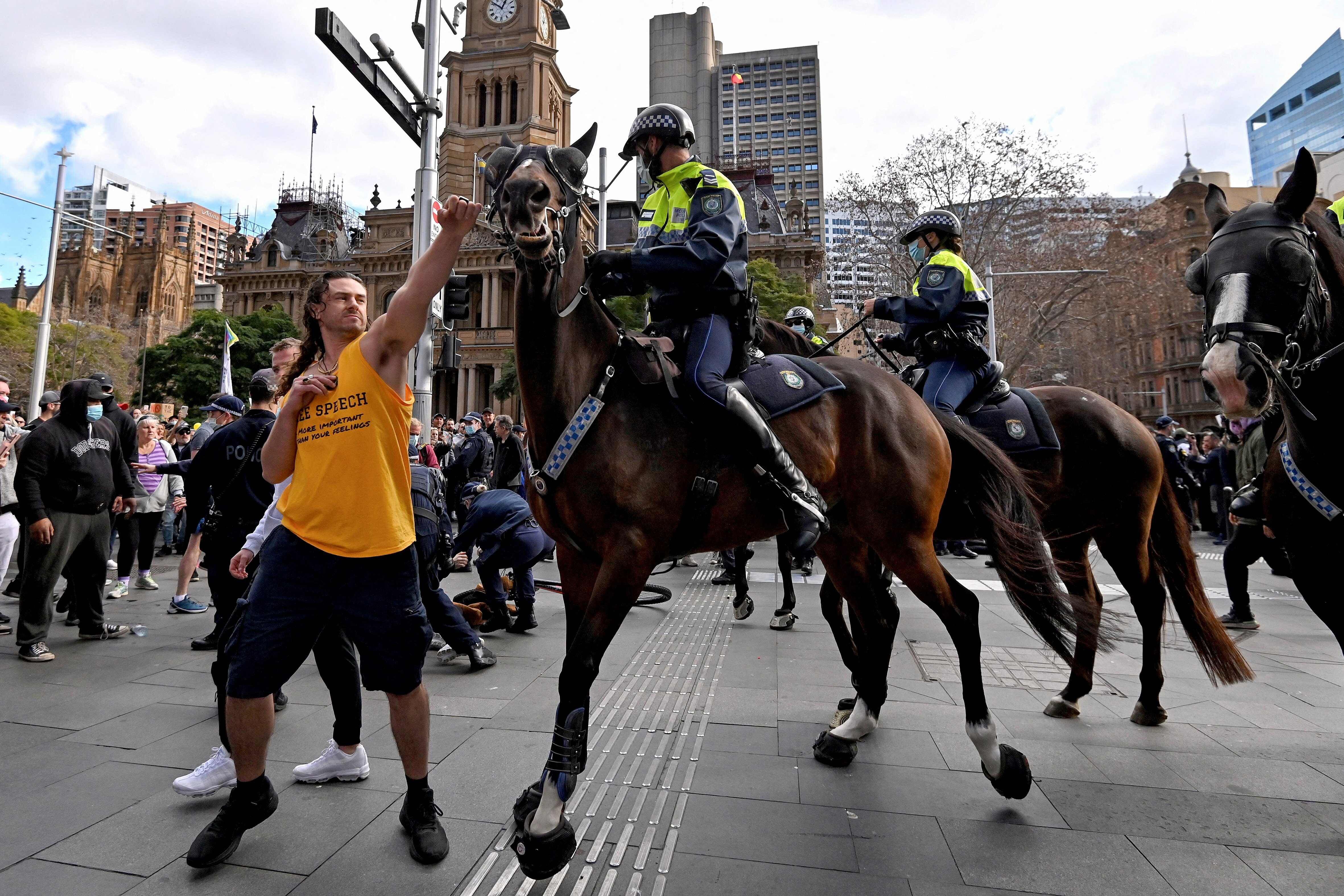 Un manifestante intenta apartar un caballo de la policía durante una manifestación contra las restricciones, en Sídney el 24 de julio.