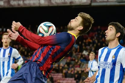 Piqué se hace con el control del balón durante un partido de liga frente a la Real Sociedad, en 2014.