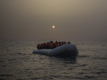 Varios refrugiados y migrantes esperan, a bordo de un un bote de goma a la deriva, a ser asistidos por miembros de la ONG española Proactiva Open Arms.