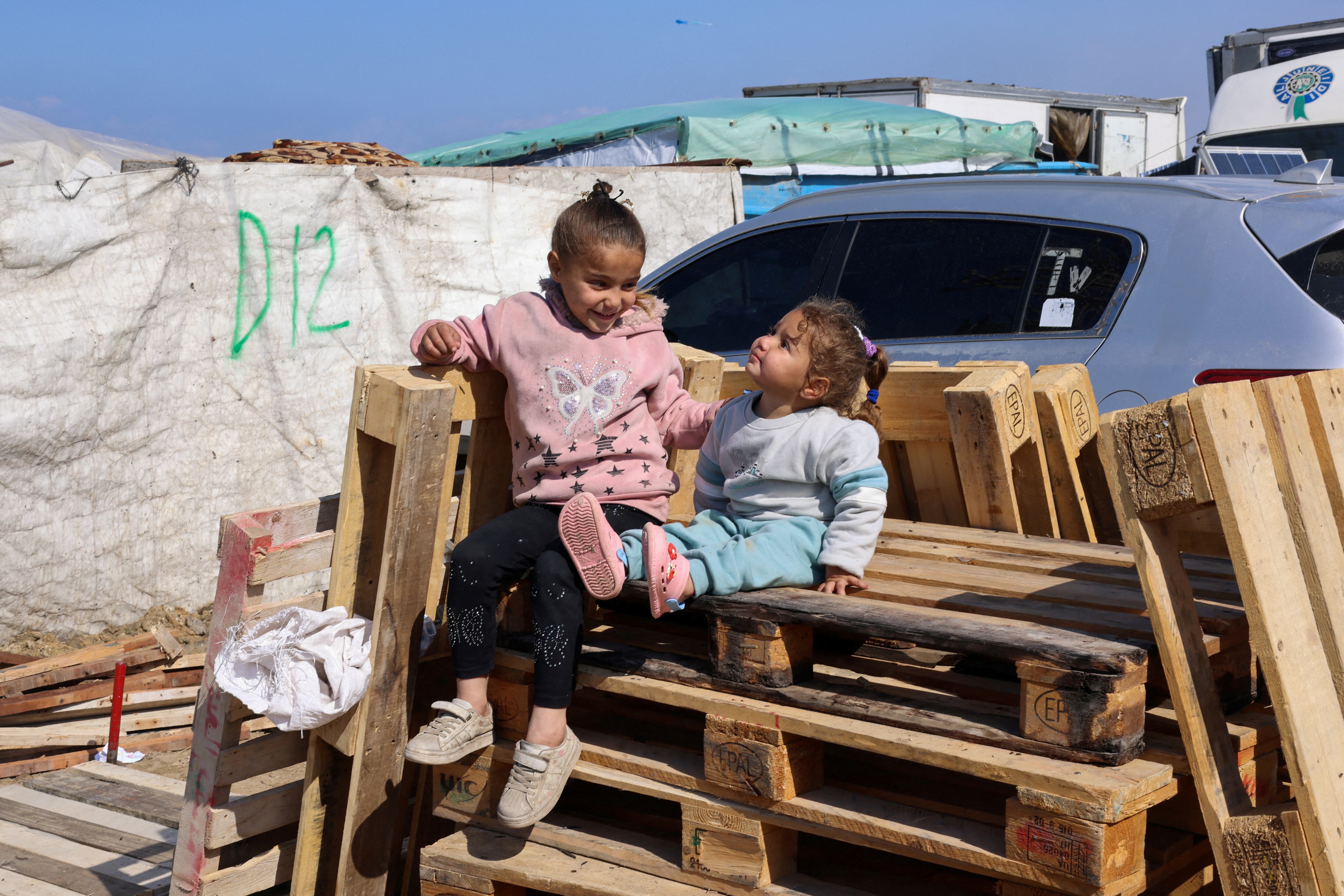 Dos niñas sentadas en unos palés en un campo de refugiados en Rafah, al sur de la franja de Gaza.