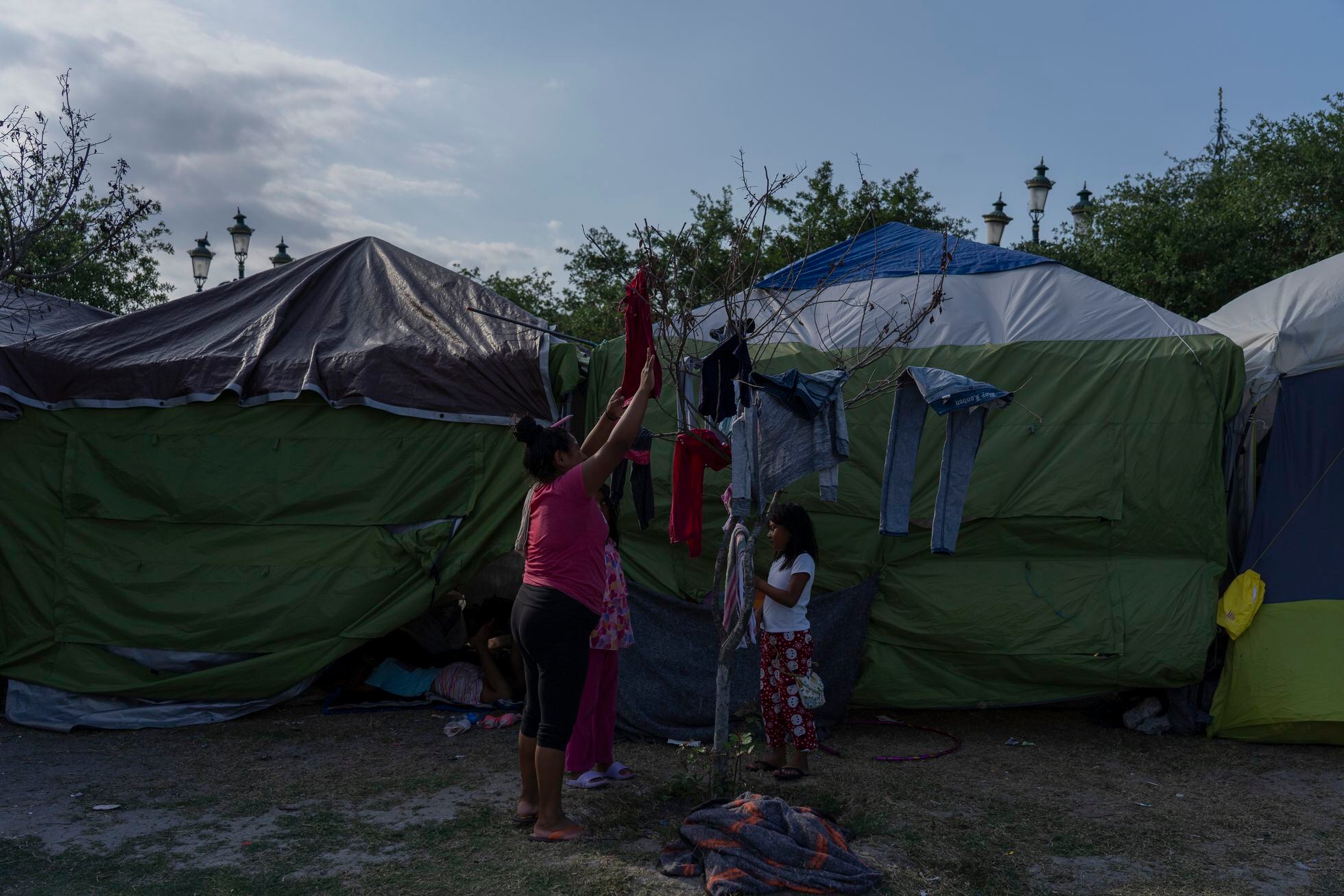 Una familia tiende su ropa a secar en el campamento de migrantes en Reynosa, Tamaulipas